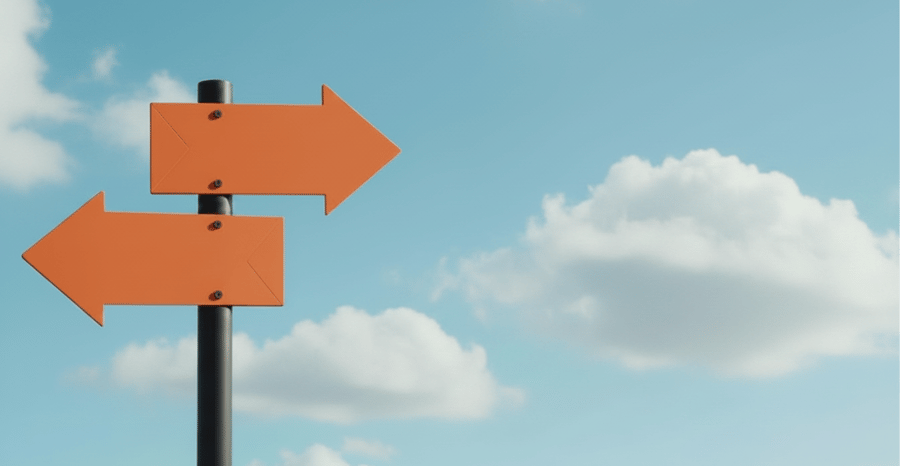 Orange directional arrows pointing in opposite directions against a blue sky with clouds.