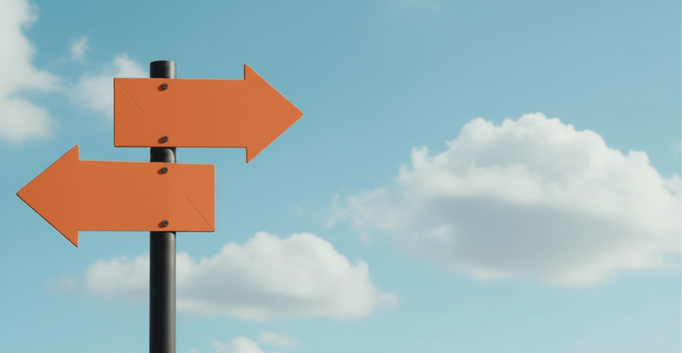 Orange directional arrows pointing in opposite directions against a blue sky with clouds.